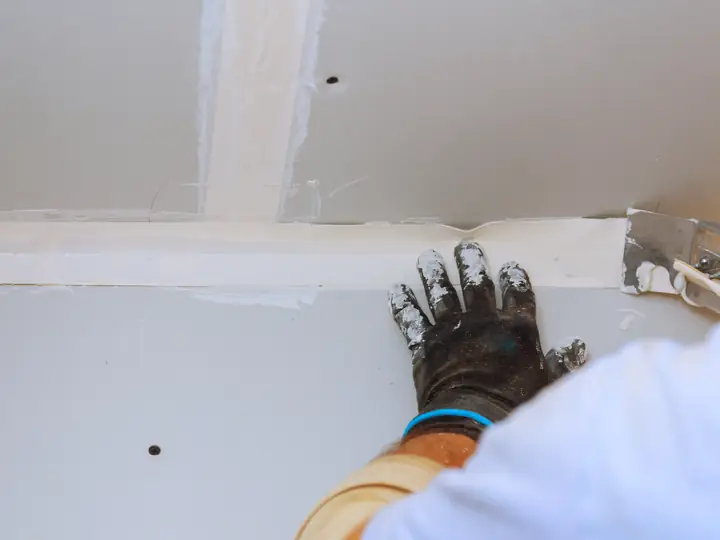 Joint compound being smoothed over a drywall seam
